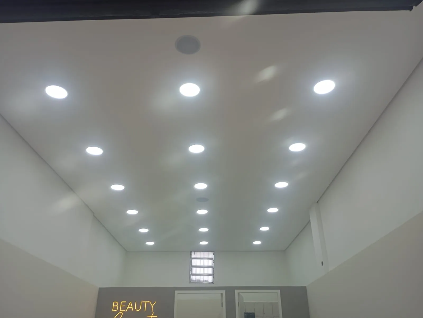 Teto com fileira de spots de LED em ambiente comercial - RBC Elétrica